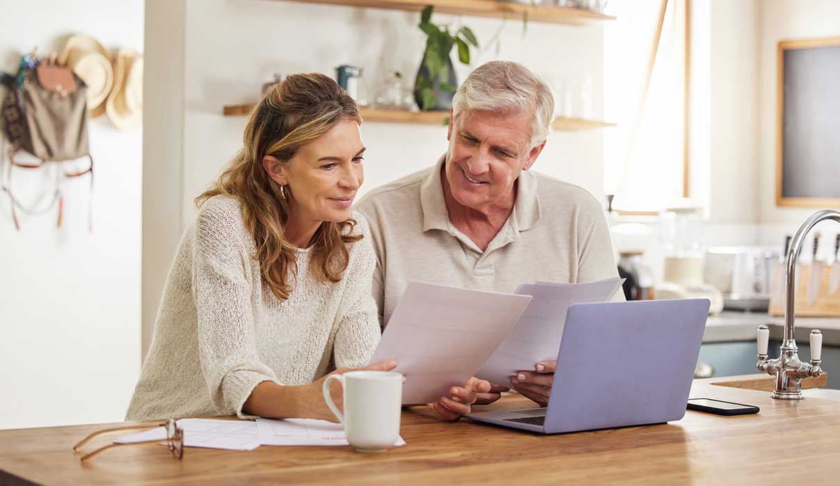 A mature couple looking at documents, smiling